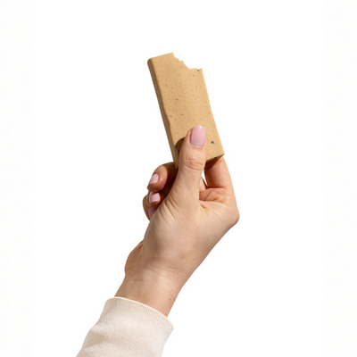 A hand holding a Caramel Cookie Dough Bar by Good Betty. 